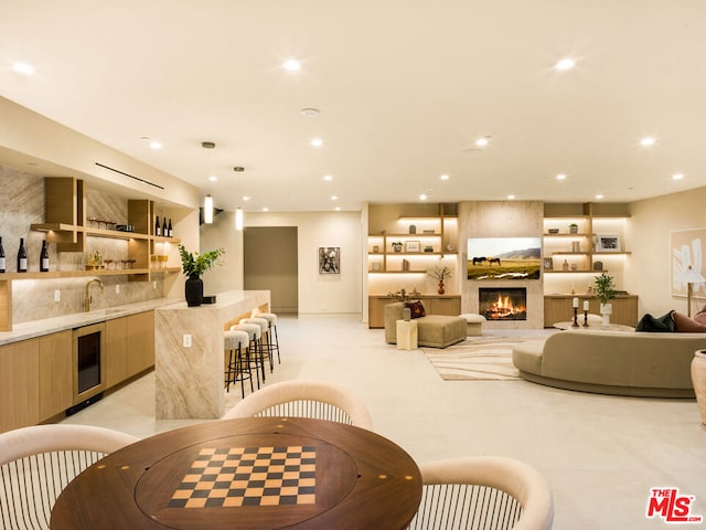 living room featuring a large fireplace, sink, and beverage cooler