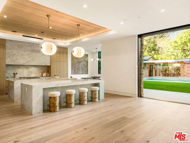 bar featuring expansive windows, wood ceiling, a raised ceiling, pendant lighting, and light hardwood / wood-style floors