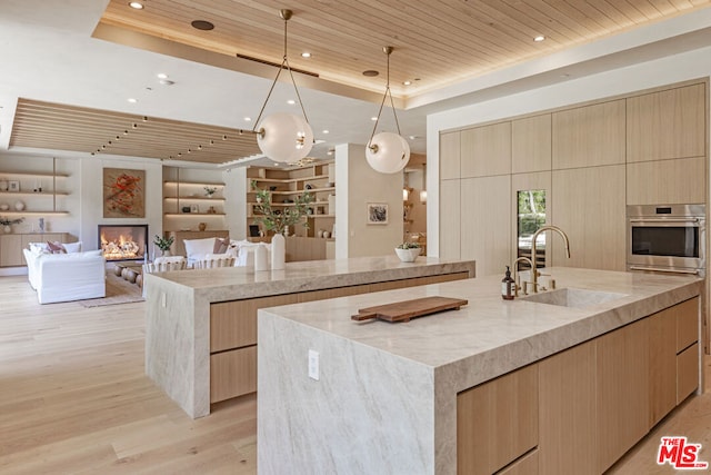 kitchen with sink, oven, a spacious island, decorative light fixtures, and wood ceiling