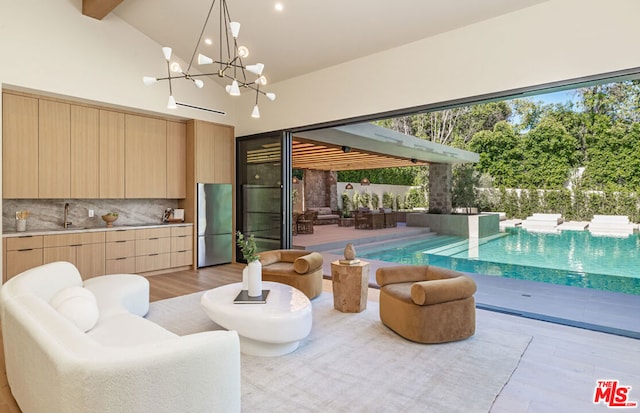 interior space featuring vaulted ceiling with beams, sink, and light hardwood / wood-style floors