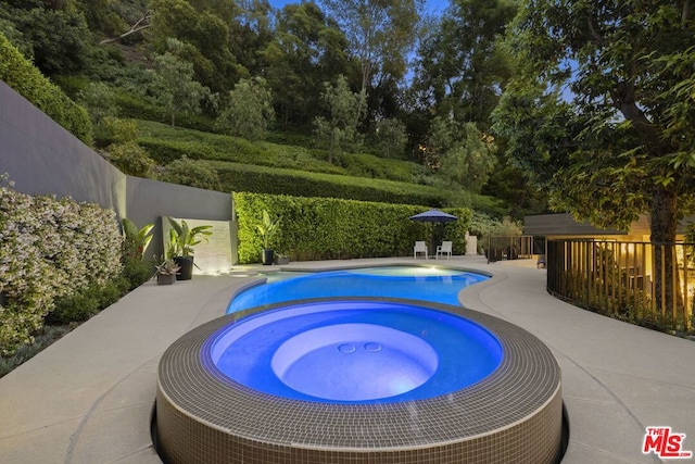 view of pool with an in ground hot tub and a patio