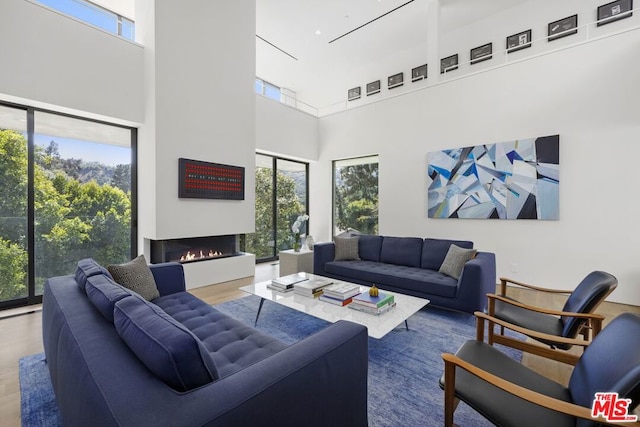 living room with wood-type flooring and a towering ceiling