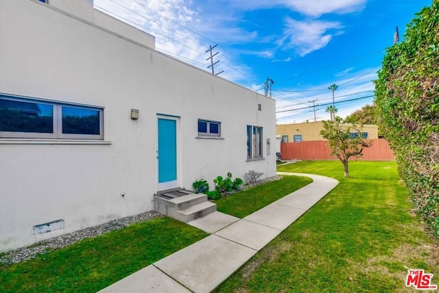 property entrance with a lawn