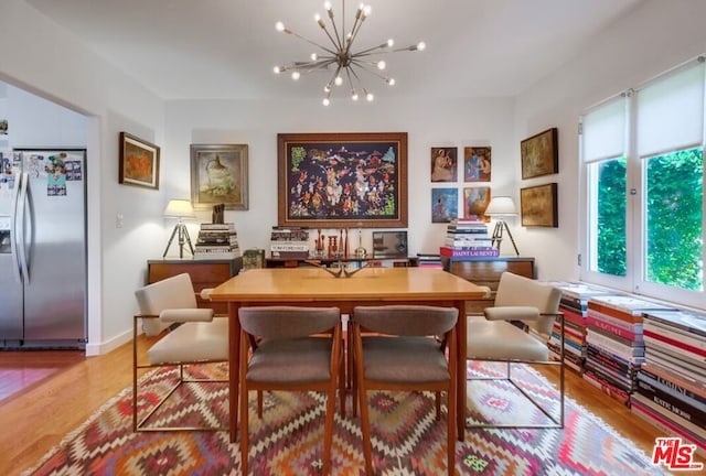 dining room featuring light wood-type flooring and an inviting chandelier