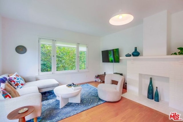 living room featuring hardwood / wood-style floors and a brick fireplace