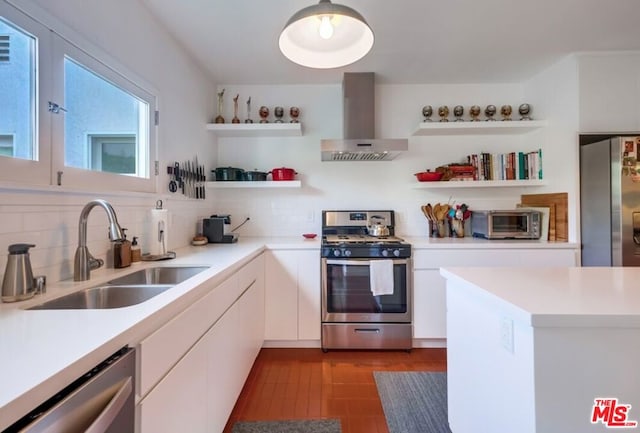 kitchen with tasteful backsplash, stainless steel appliances, sink, wall chimney range hood, and white cabinets