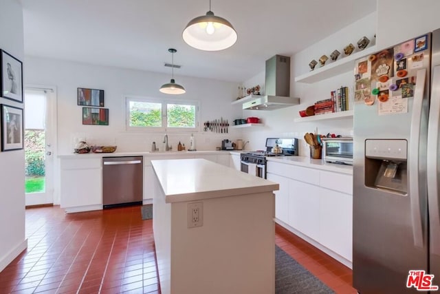 kitchen with white cabinetry, stainless steel appliances, wall chimney range hood, pendant lighting, and a kitchen island