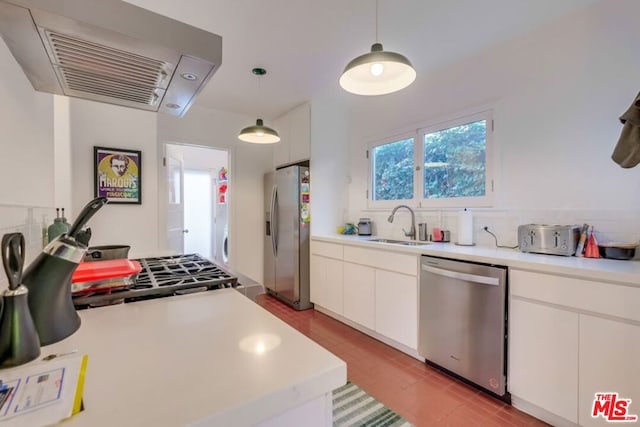 kitchen with sink, hanging light fixtures, range hood, appliances with stainless steel finishes, and white cabinetry