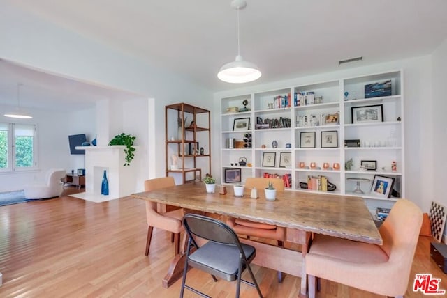 dining room with built in features and light hardwood / wood-style flooring