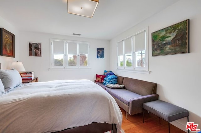 bedroom featuring multiple windows and hardwood / wood-style flooring