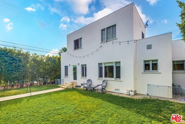 rear view of house featuring a lawn