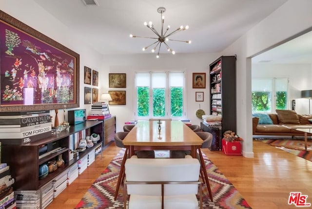 dining room featuring light hardwood / wood-style floors and a notable chandelier