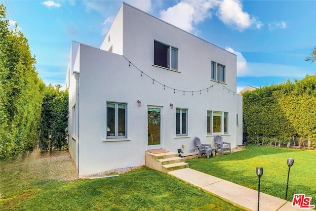 rear view of house featuring a yard