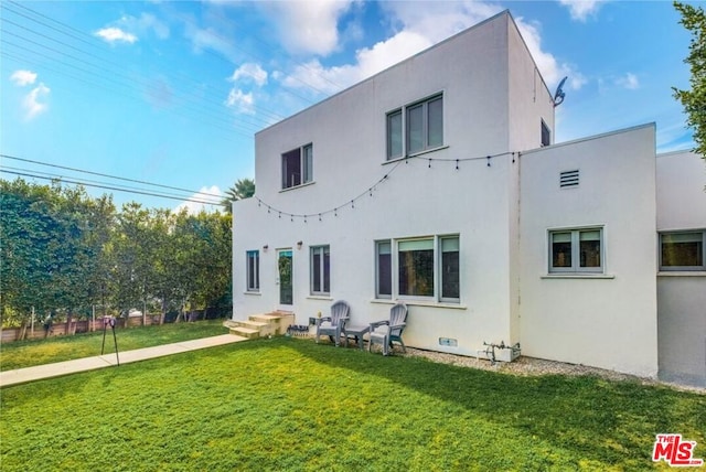 rear view of house featuring a lawn