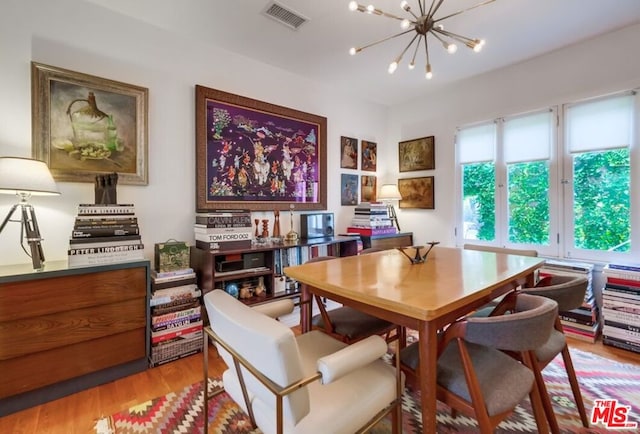 dining room with light hardwood / wood-style floors and a notable chandelier