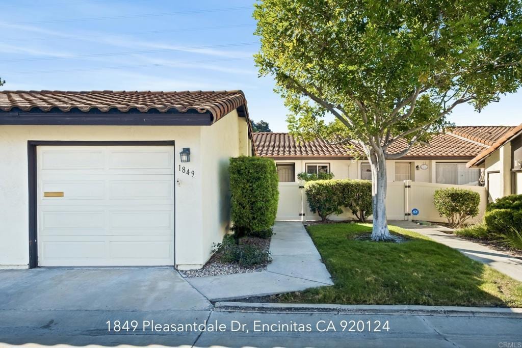 mediterranean / spanish house with a front yard and a garage