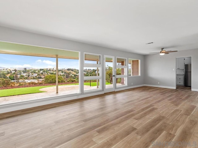 unfurnished living room featuring ceiling fan and light hardwood / wood-style flooring