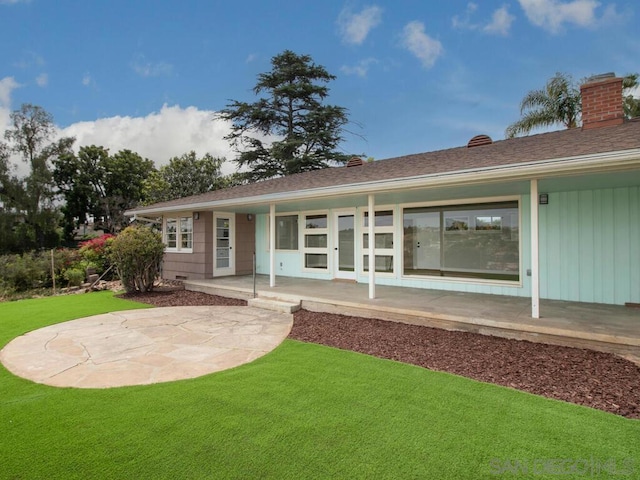 rear view of house with a patio area and a lawn