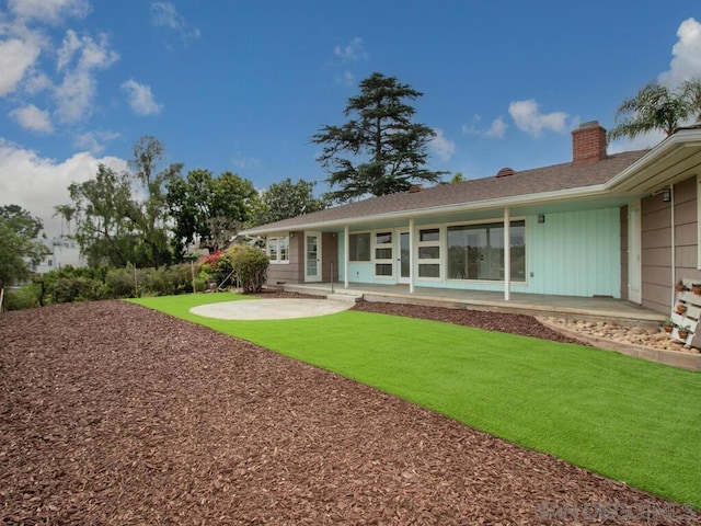 back of property with a patio area and a lawn