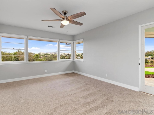 empty room featuring ceiling fan and carpet flooring