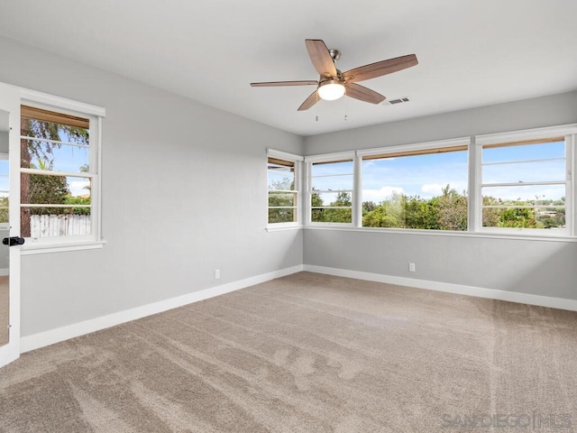 carpeted empty room featuring ceiling fan and a healthy amount of sunlight