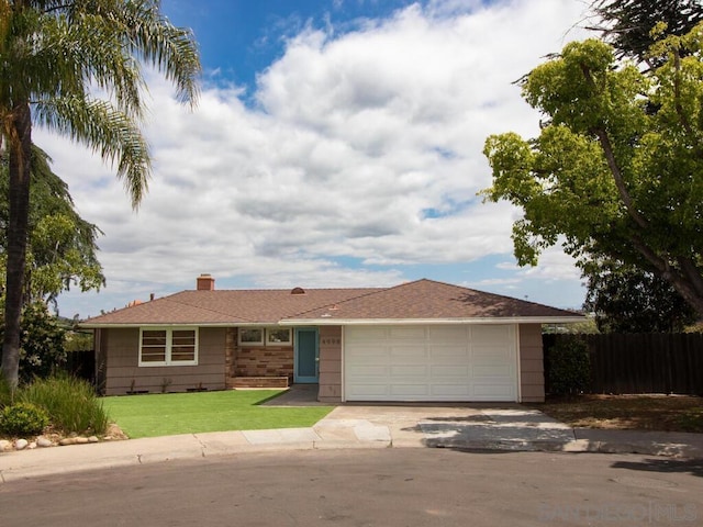 ranch-style house with a garage and a front lawn