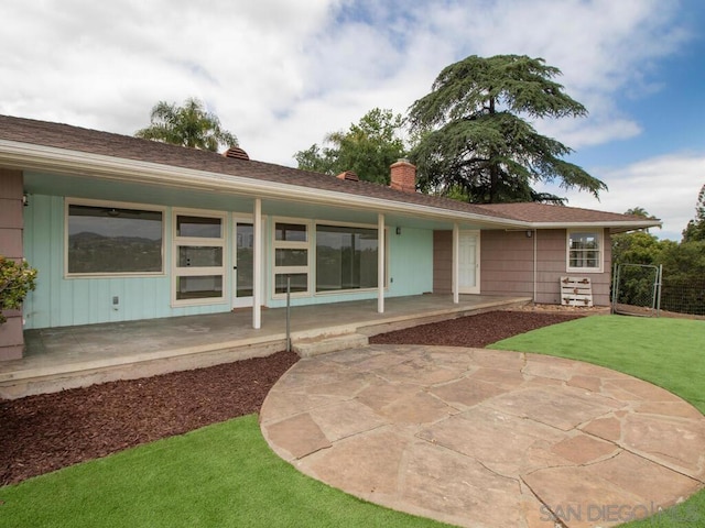 rear view of property with a yard and a patio area