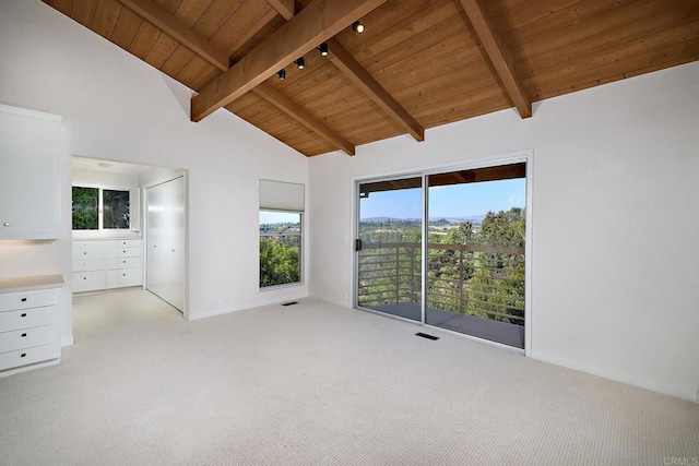 unfurnished bedroom with access to outside, beamed ceiling, light colored carpet, and wooden ceiling