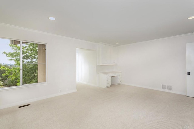 unfurnished room with light colored carpet and crown molding