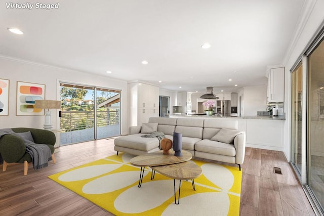 living room featuring light hardwood / wood-style flooring and ornamental molding