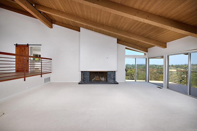 unfurnished living room with beamed ceiling, carpet, a barn door, and wood ceiling