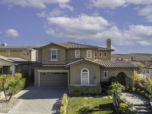 mediterranean / spanish house featuring a front lawn and a garage