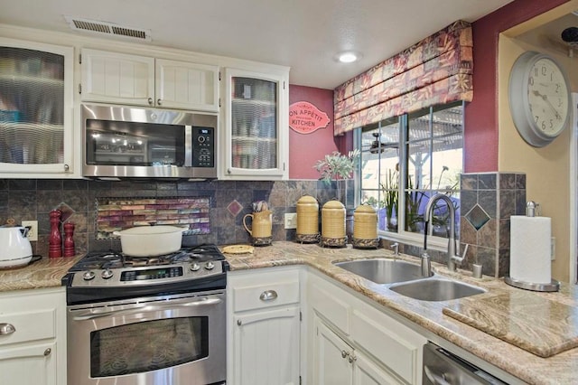 kitchen with backsplash, white cabinetry, sink, and appliances with stainless steel finishes