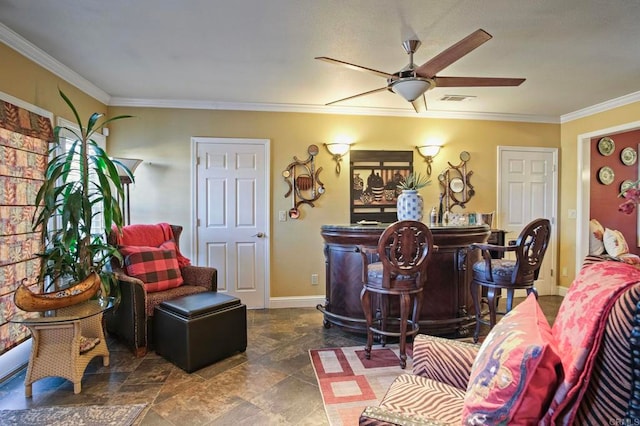 living room with bar area, ceiling fan, and crown molding