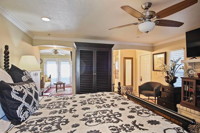 bedroom featuring french doors, a textured ceiling, ceiling fan, and ornamental molding