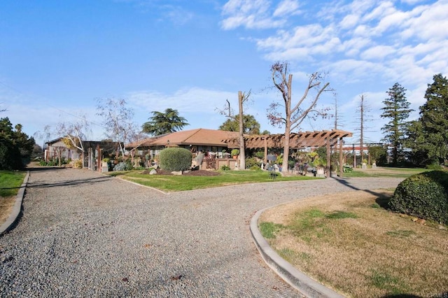 ranch-style home with a pergola and a front yard