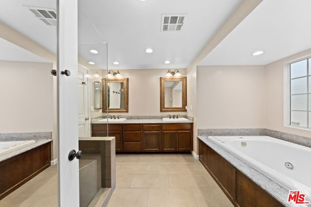 bathroom with a bathing tub, tile patterned flooring, and vanity