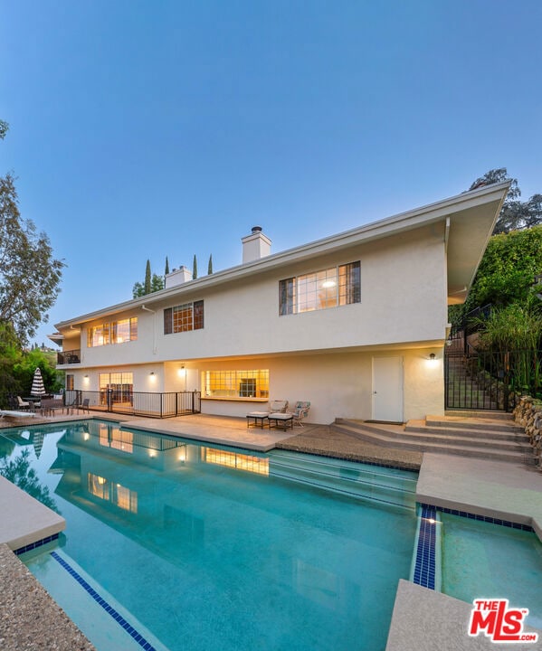 pool at dusk with a patio