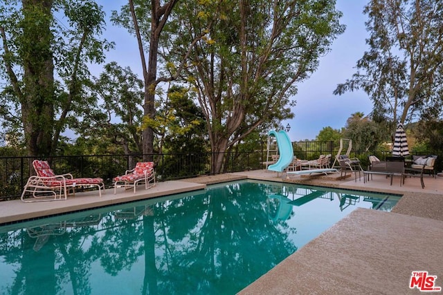 view of swimming pool featuring a patio area and a water slide