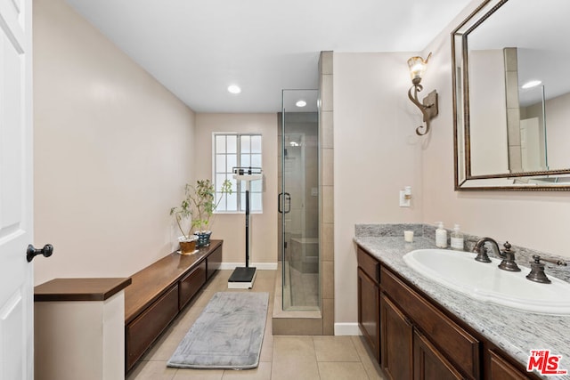 bathroom with tile patterned flooring, vanity, and walk in shower