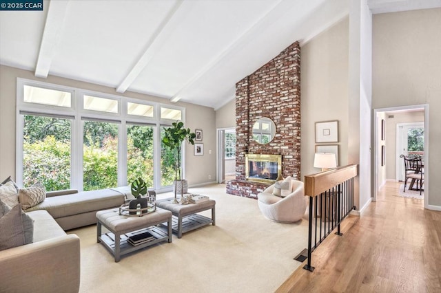 living room featuring a fireplace, beamed ceiling, plenty of natural light, and high vaulted ceiling