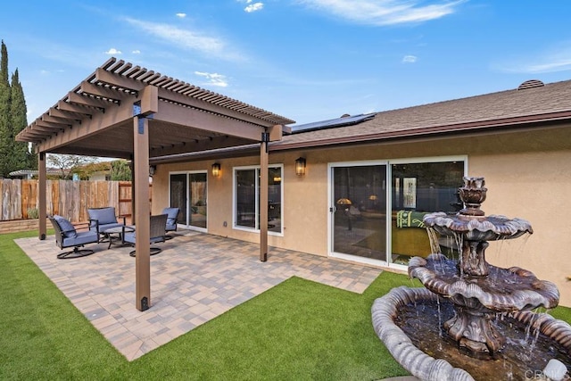 back of house featuring a pergola, a lawn, a patio, and solar panels