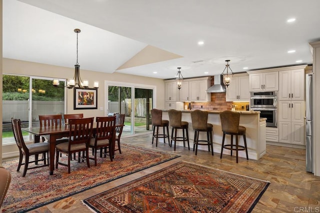 dining area featuring lofted ceiling, a healthy amount of sunlight, and a chandelier