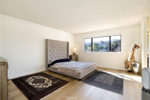 bedroom featuring a textured ceiling, light wood-type flooring, and crown molding