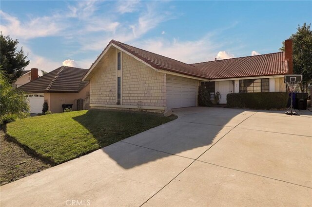 ranch-style house featuring a front yard, a garage, and cooling unit