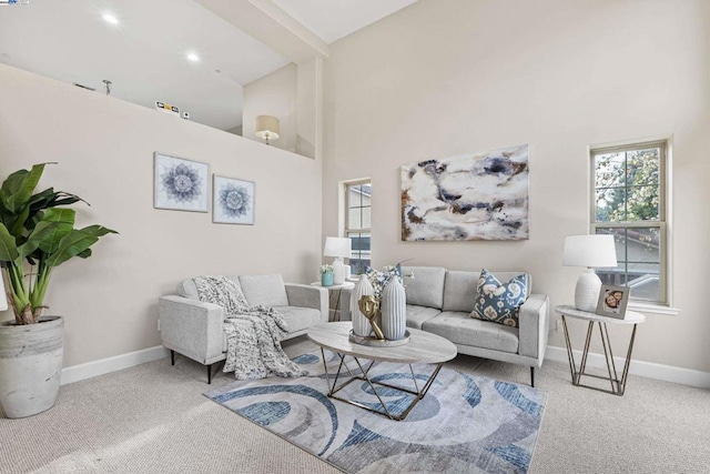 carpeted living room featuring a high ceiling