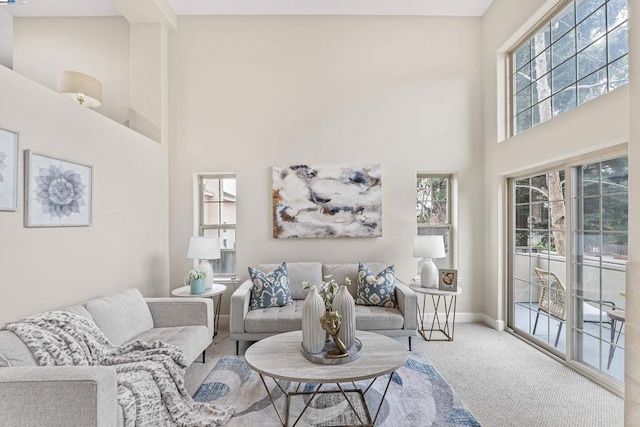 carpeted living room featuring a towering ceiling and a wealth of natural light