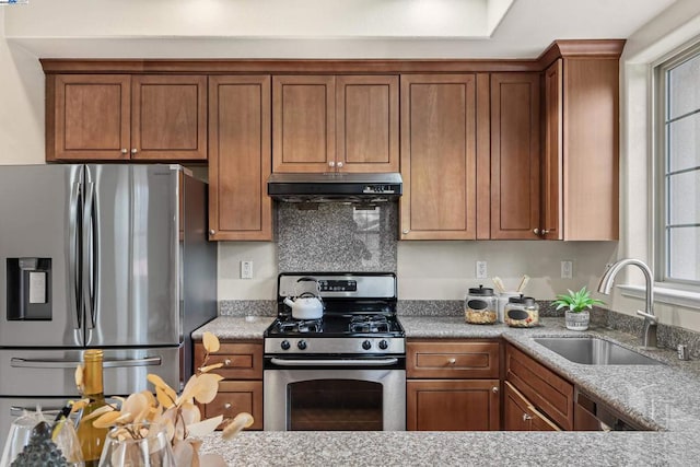 kitchen featuring stainless steel appliances, sink, and light stone counters