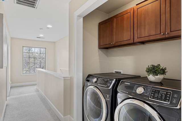 clothes washing area featuring separate washer and dryer and light colored carpet