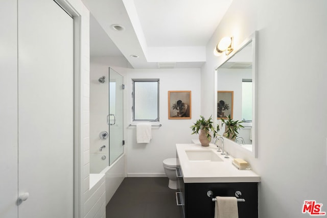 full bathroom with combined bath / shower with glass door, toilet, and vanity